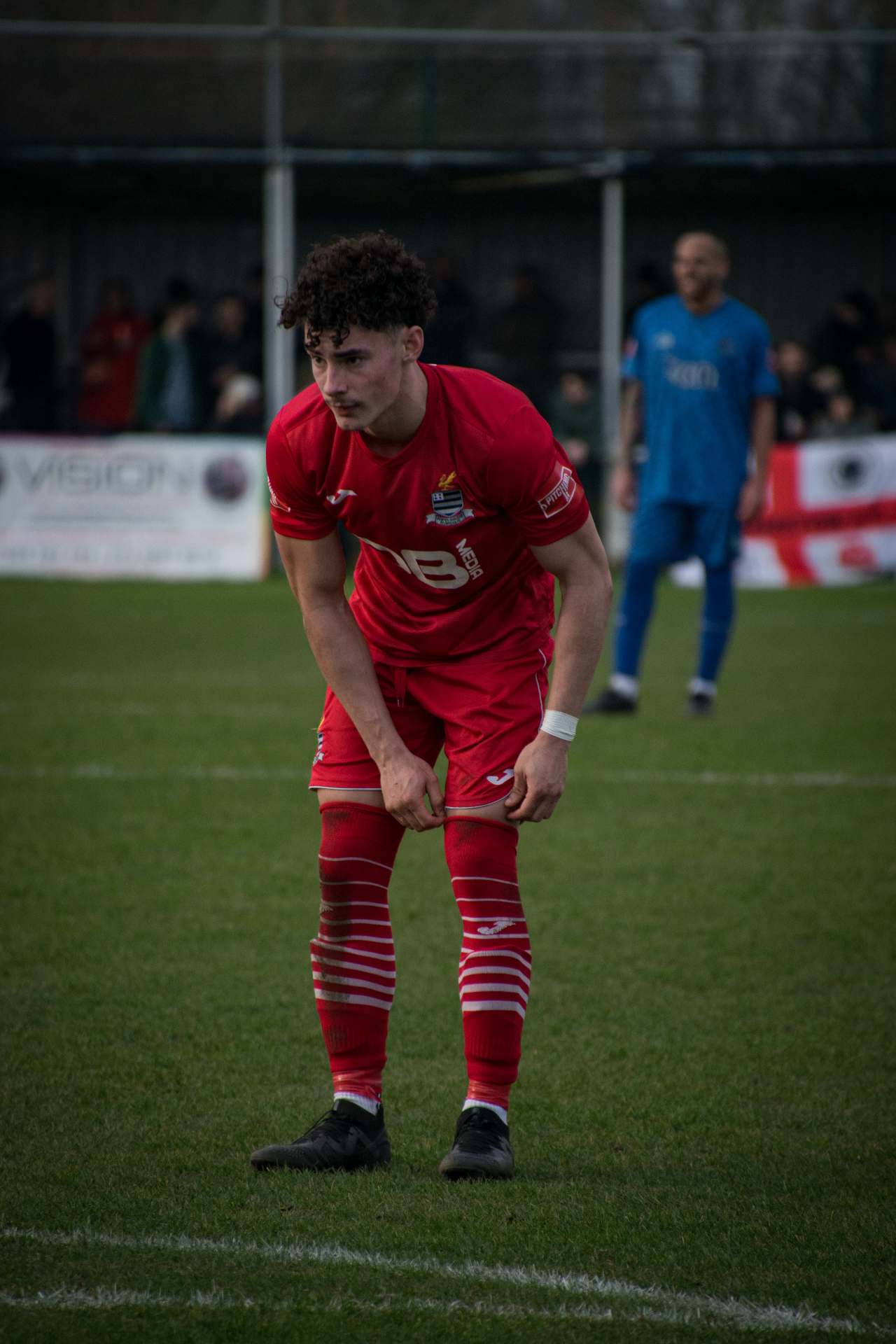 Football player in red kit on pitch