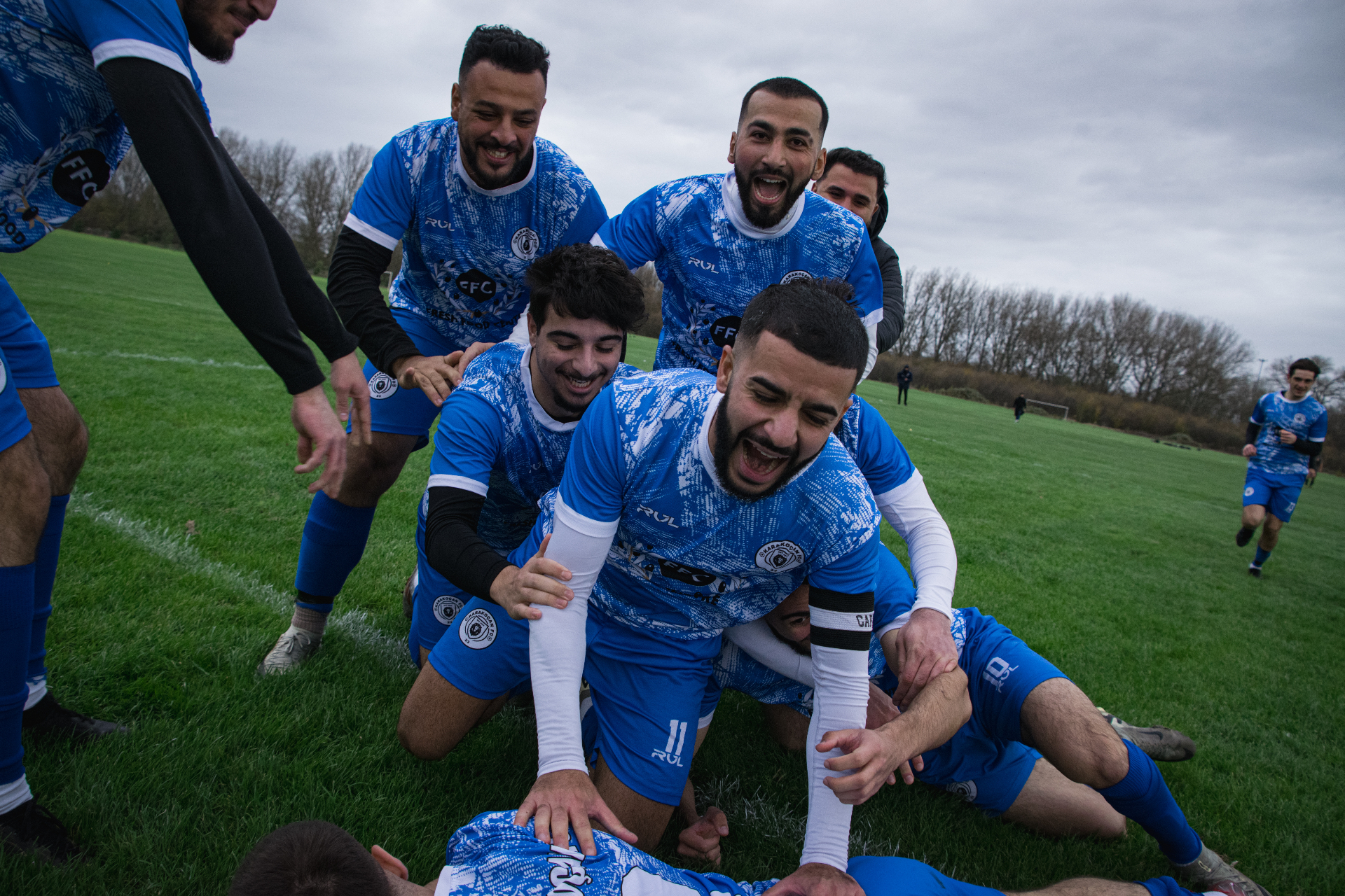 Team celebrating a goal in blue kits
