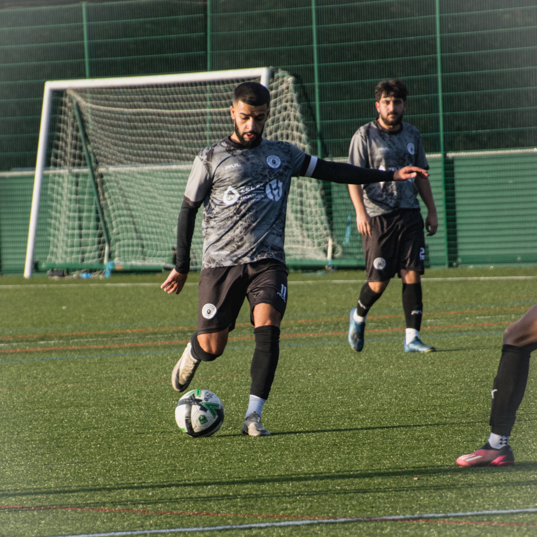 Midfielder carrying the ball in front of goal