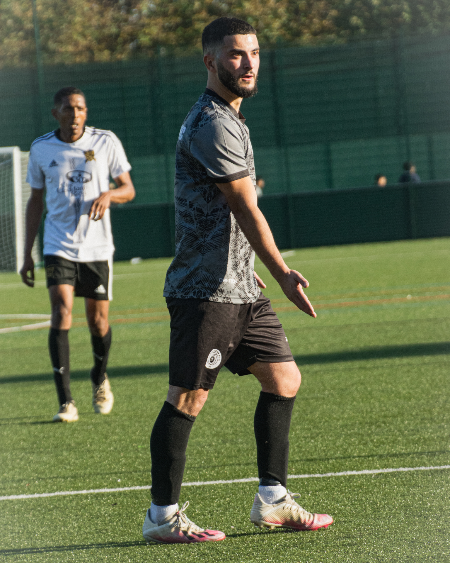Midfielder pausing on the pitch in golden light