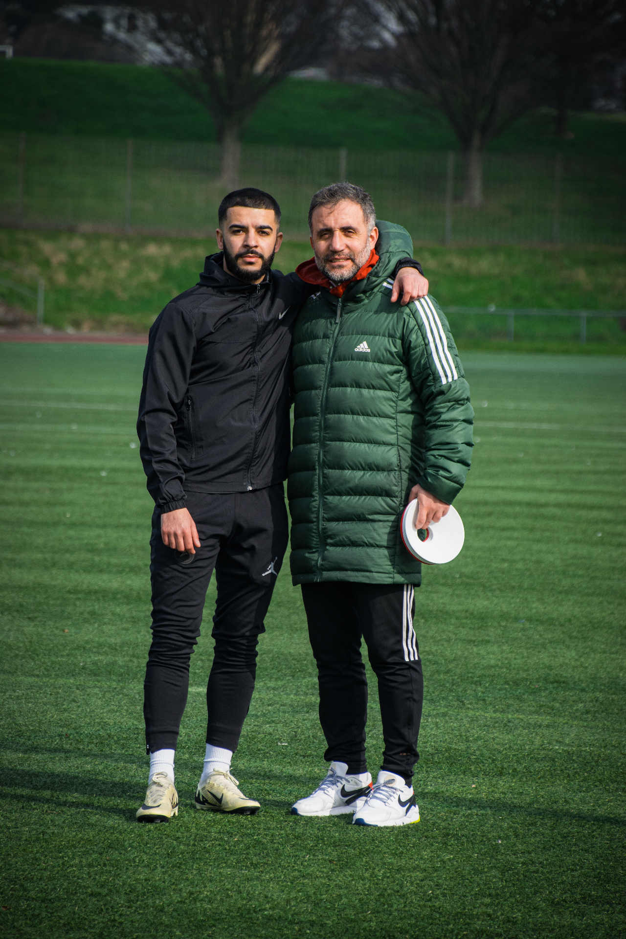 Portrait, coach and player on pitch